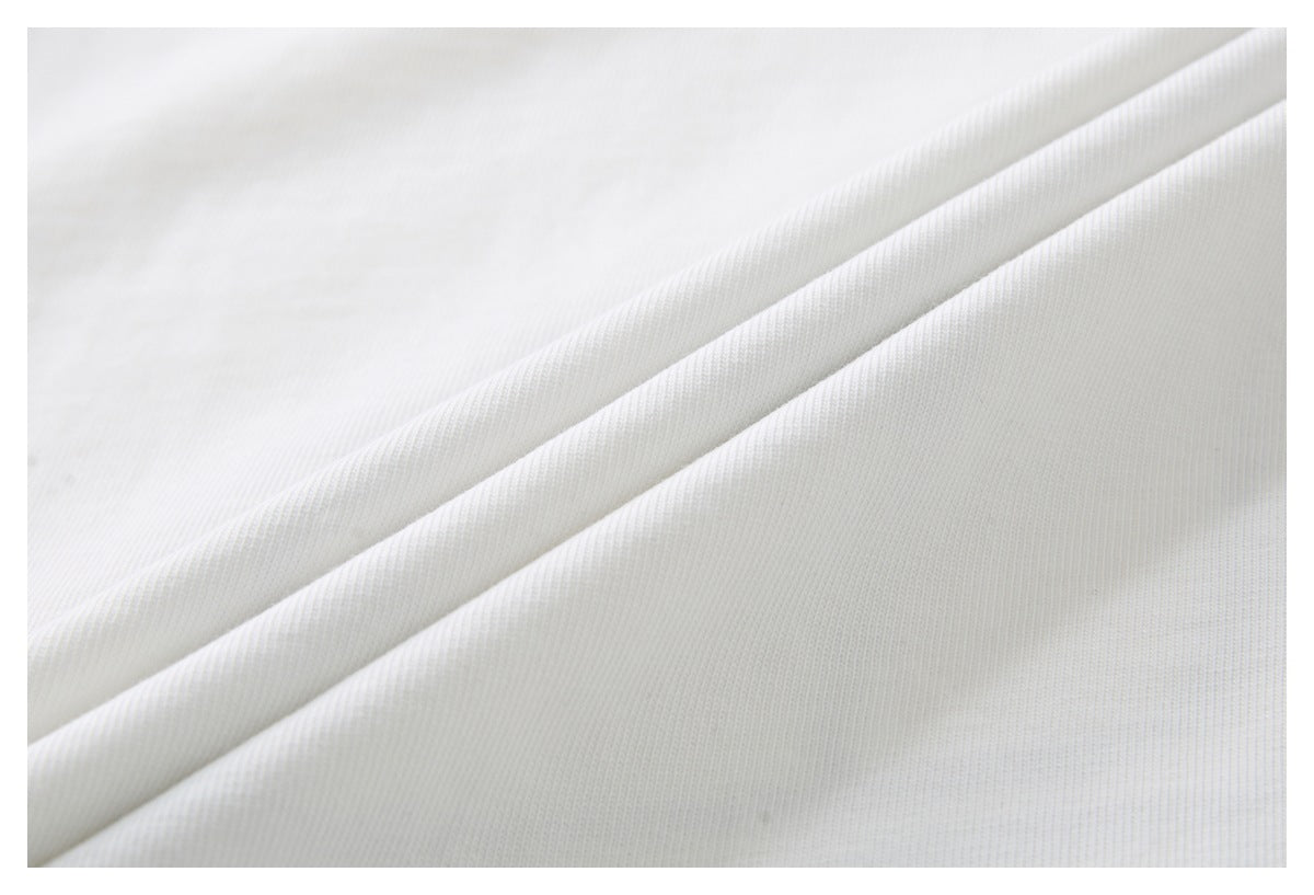Macro view of white T-shirt fabric draped in soft folds, showing its surface texture.