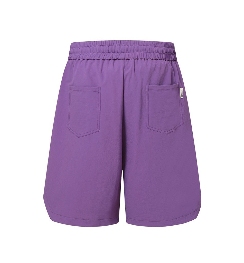 Purple knee-length shorts shown from the back, with an elastic waistband and two patch pockets.