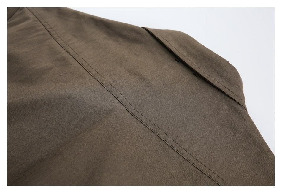 Close-up of a folded collar or lapel and long stitched seam on a brown garment.