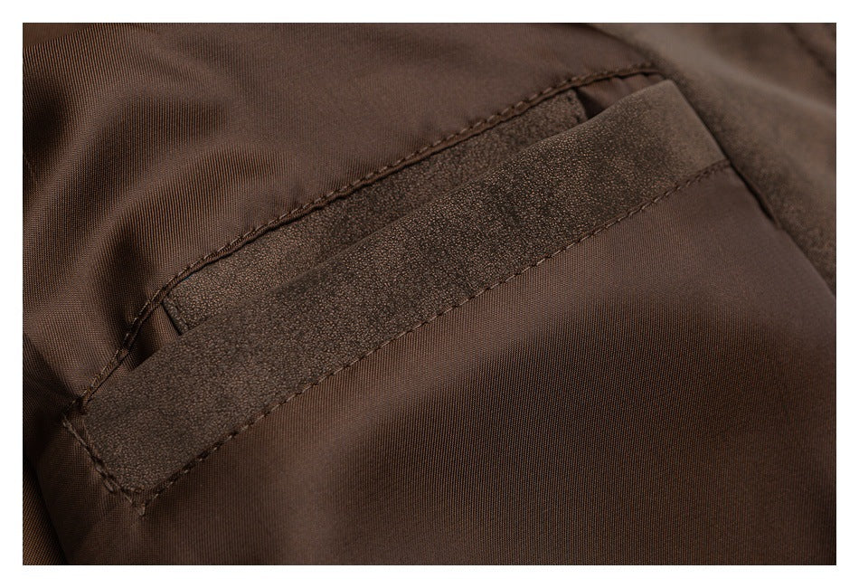 Close-up of dark brown garment fabric with a diagonal stitched pocket opening and textured trim.