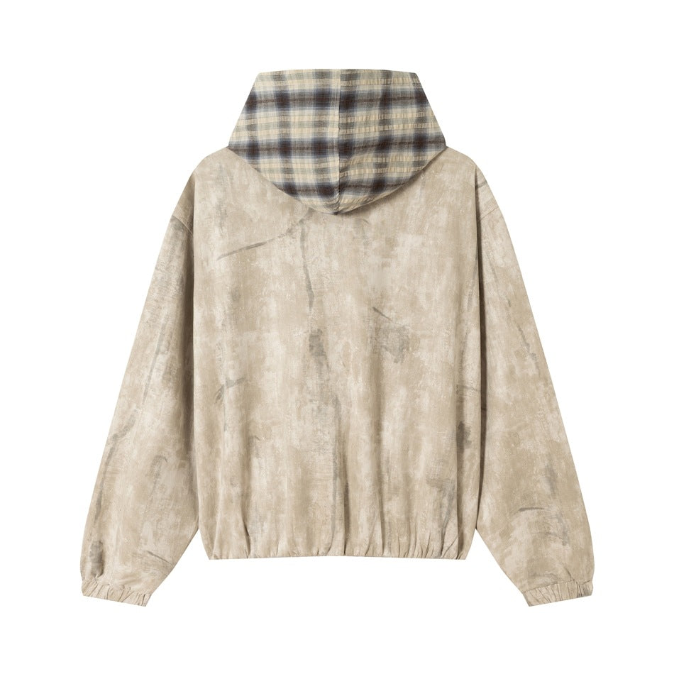 Back view of a light beige mottled jacket with a plaid-lined hood, elastic cuffs and hem, displayed on white.