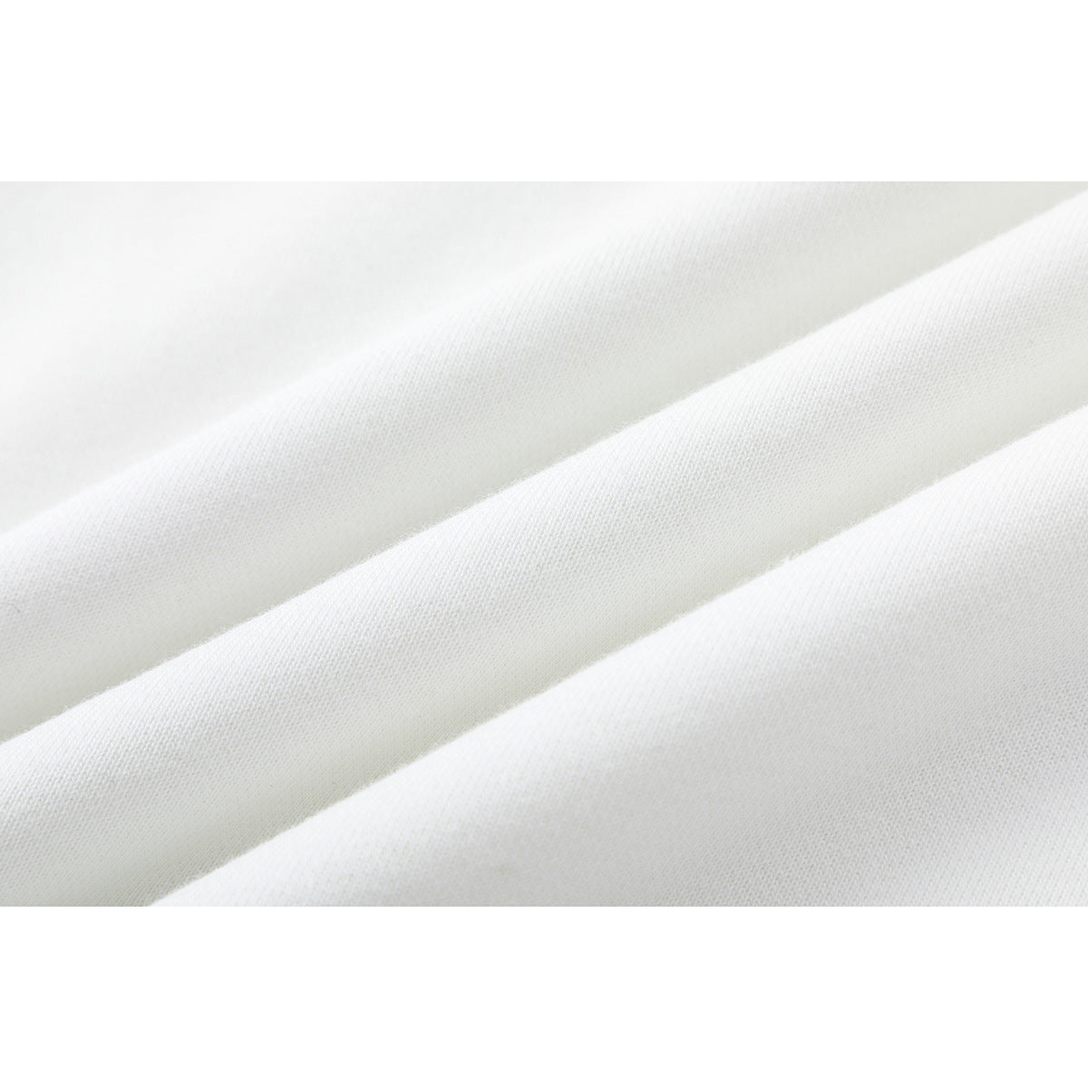 Close-up of white fabric arranged in soft diagonal folds, showing its fine knit texture.