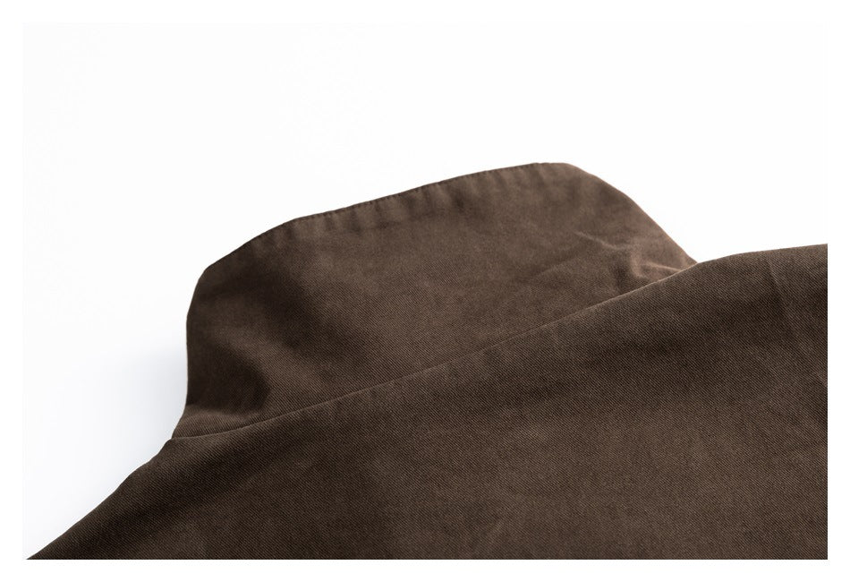 Close-up of the dark brown jacket's raised collar and upper shoulder seam.