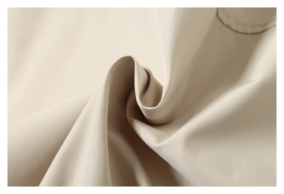 Close-up of beige fabric gathered into a soft fold, showing its surface texture.