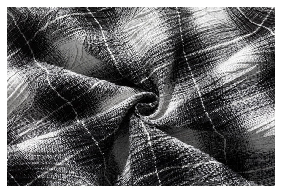 Close-up showing the black-and-white plaid fabric's woven texture and drape.