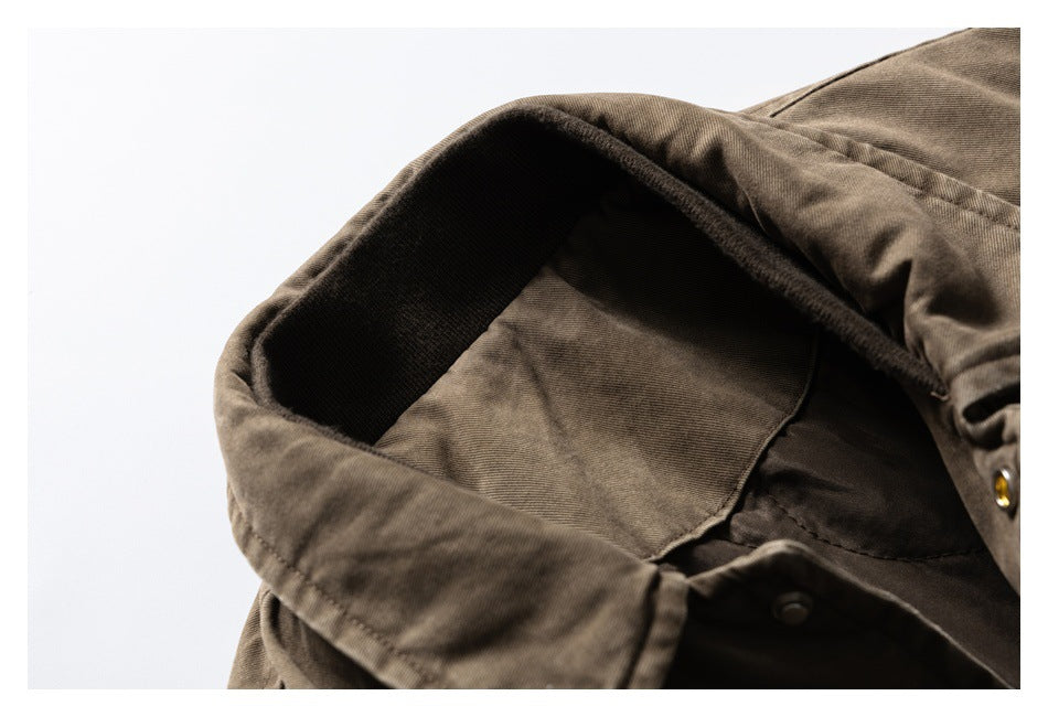 Close-up of the brown jacket’s folded collar, dark inner lining, and snap fastening.