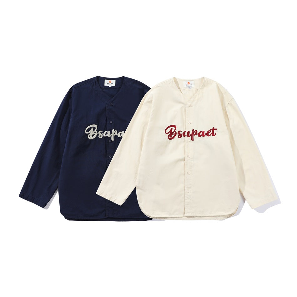 Two long-sleeved button-front shirts displayed together: navy with light embroidery and ivory with red embroidery.
