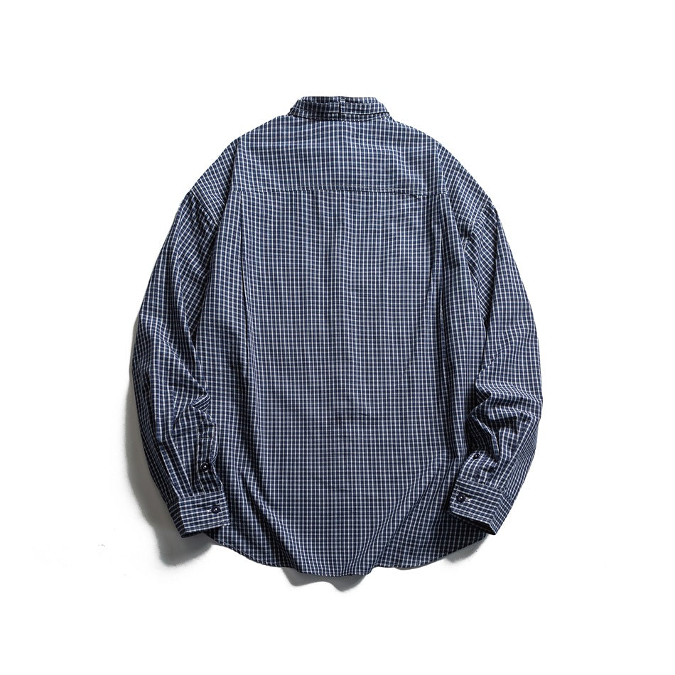 Back view of navy and white small-check plaid long-sleeve shirt with back yoke seam, button cuffs and curved hem