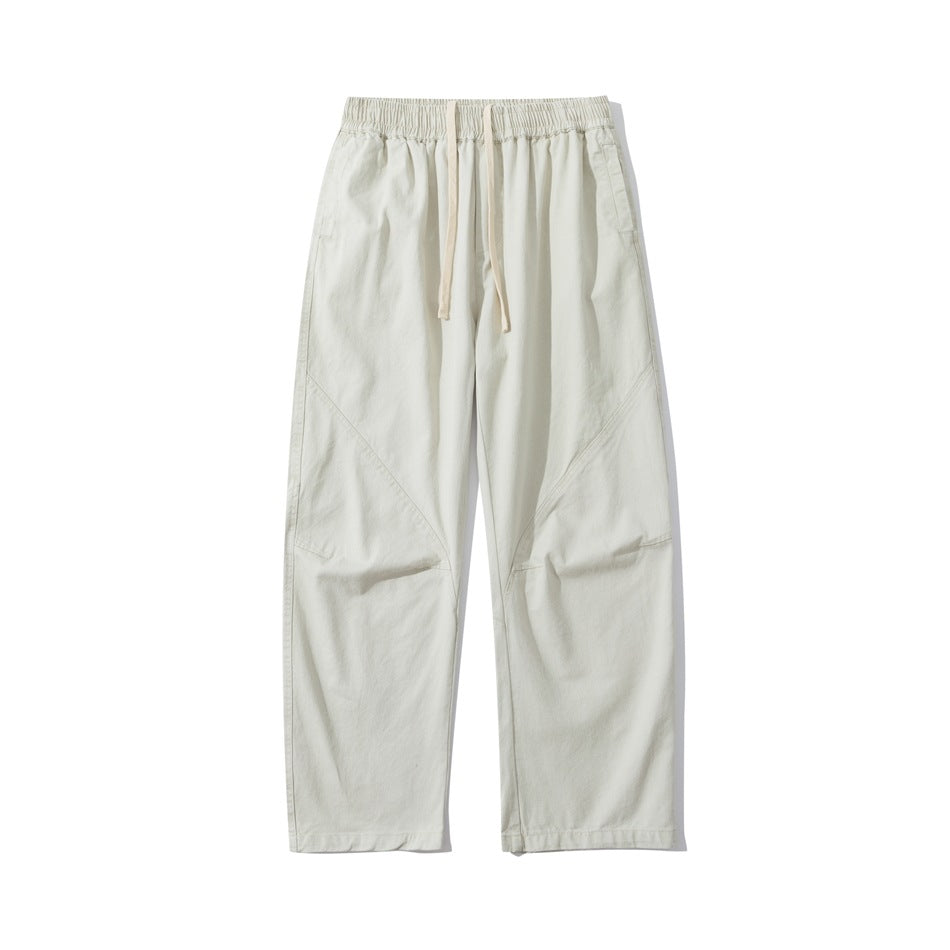 Beige straight-leg drawstring pants with elastic waistband and diagonal seams, flat front view