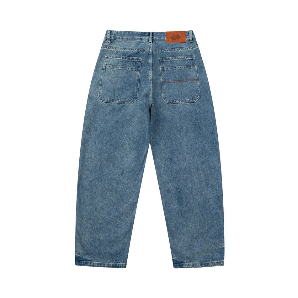 Back view of blue jeans with two patch pockets and a brown waistband patch.