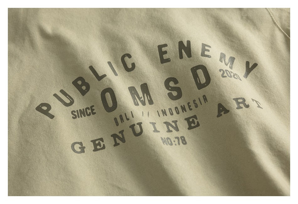 Close-up of a khaki garment with a distressed dark English text graphic printed across the fabric.