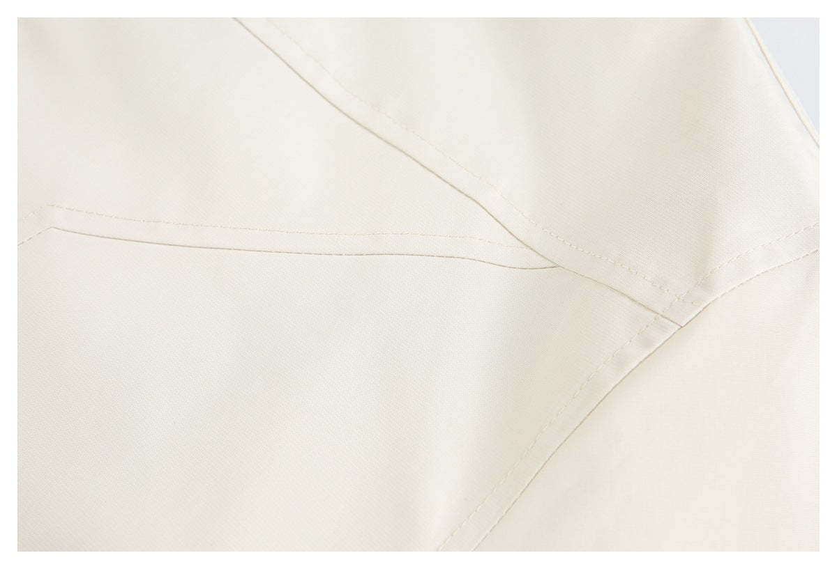 Close-up of intersecting stitched seams on cream fabric.