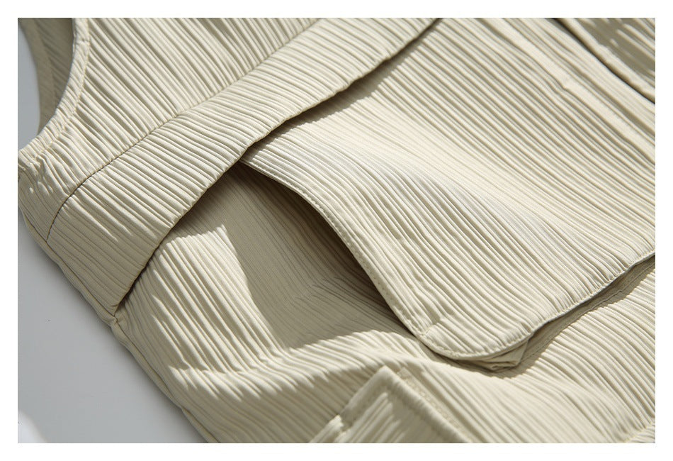 Close-up of an ivory ribbed jacket with a curved flap pocket and layered stitching.