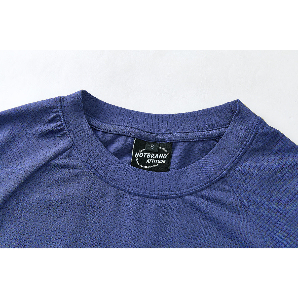 Close-up of a blue long-sleeve shirt's ribbed crew neck and black inner label.