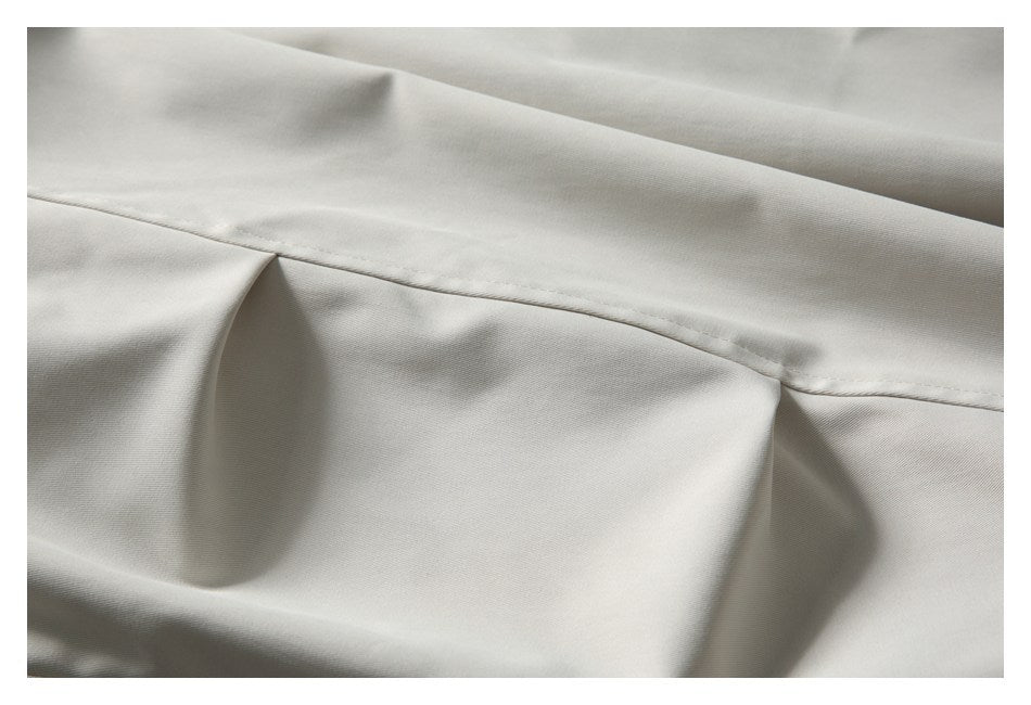 Close-up of a stitched seam across smooth off-white garment fabric.