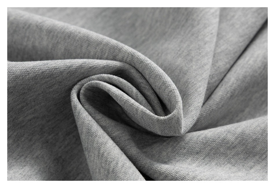 Close-up of gray knit fabric gathered into a soft fold, showing its surface texture.