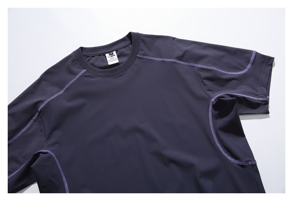 Close-up of the front and shoulder of a dark navy crew-neck shirt with purple contrast stitching.