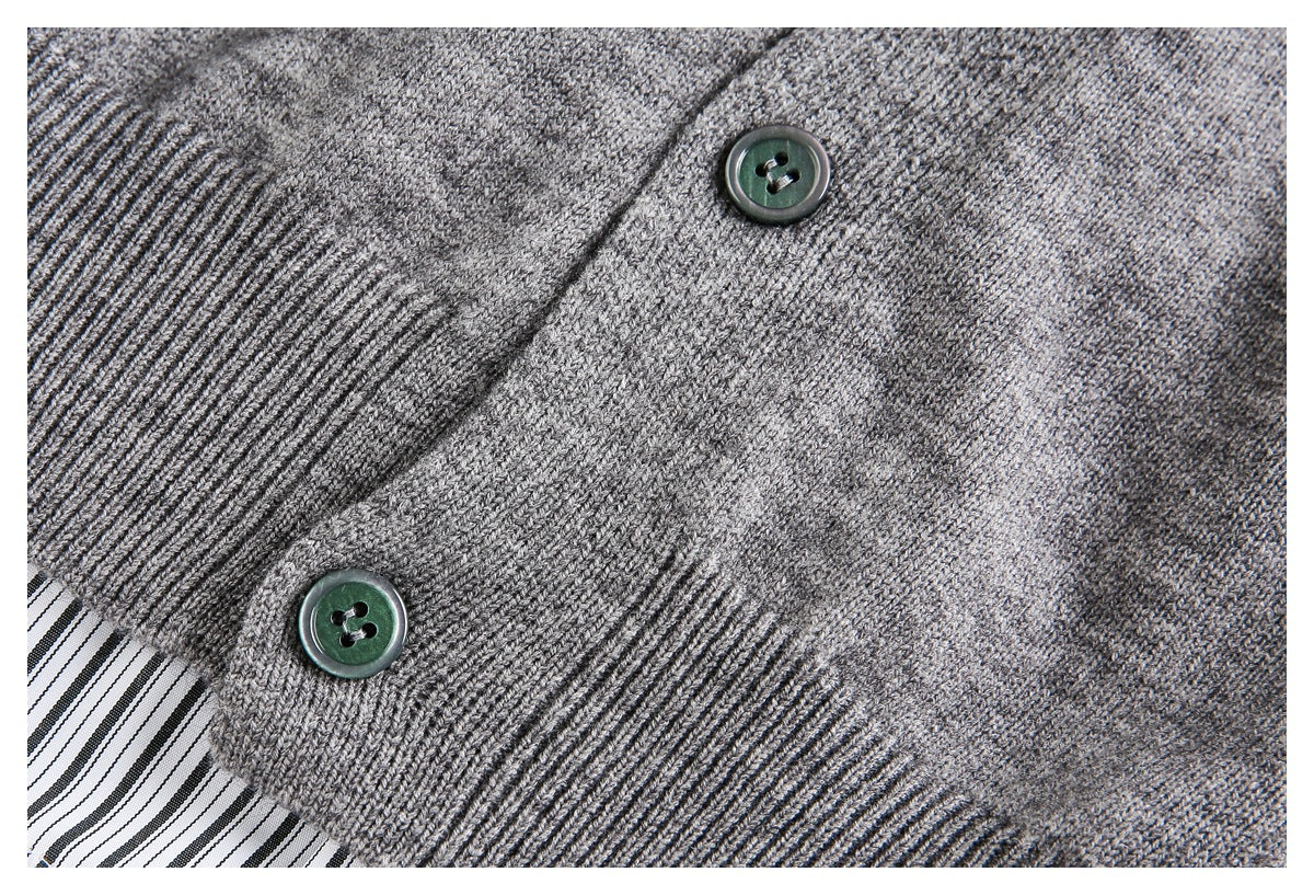 Close-up of a gray knit cardigan front with dark buttons and ribbed trim.