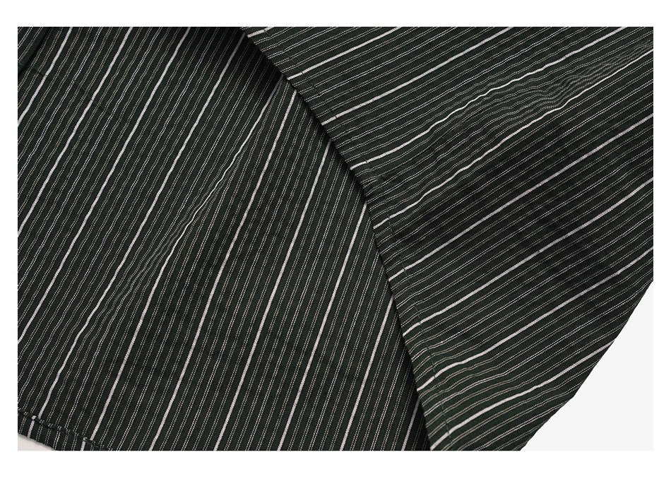Close-up of dark striped garment panels meeting at a seam; narrow white stripes run at different angles.