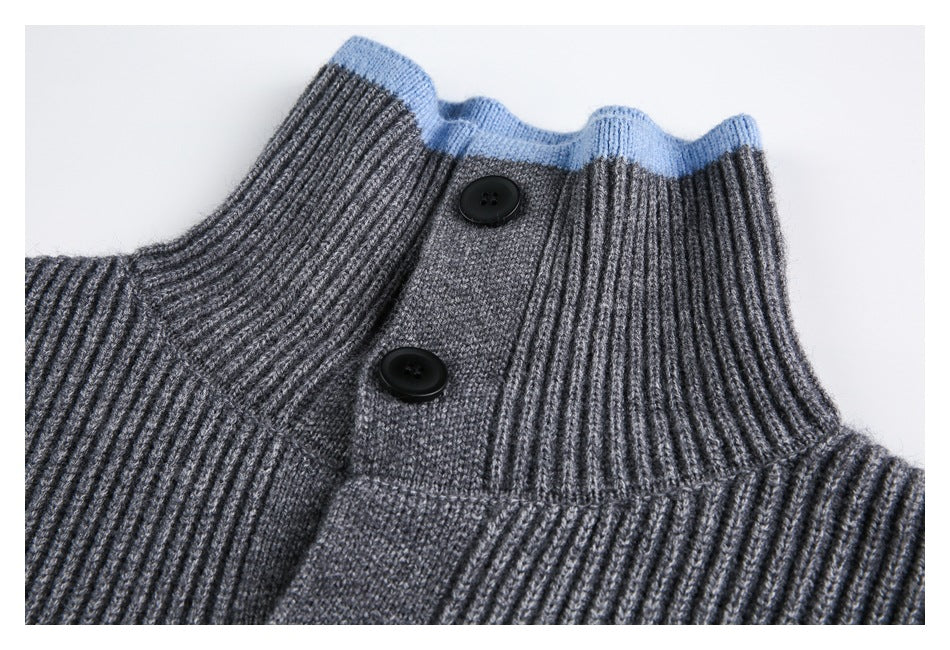 Close-up of a gray ribbed sweater's high collar, blue edging, and two-button placket.
