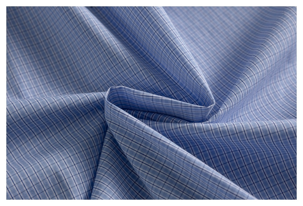 Close-up of blue and white plaid fabric arranged in soft folds.