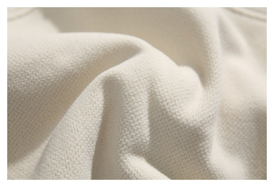 Close-up showing the raised, nubby texture of ivory garment fabric.