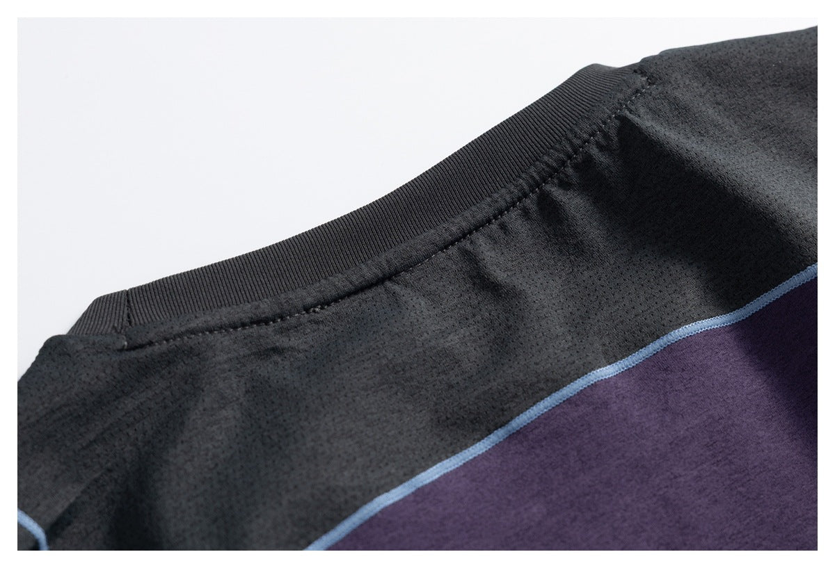 Close-up of the black ribbed neckline and textured black fabric above a purple panel edged with blue piping.