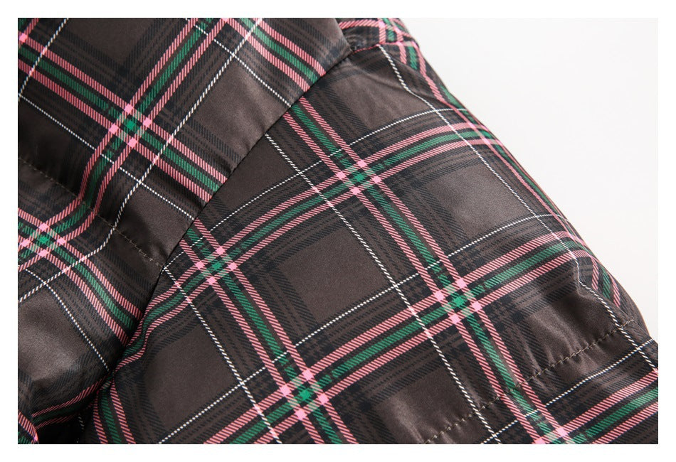Close-up of the plaid jacket's shoulder and quilted sleeve seam.