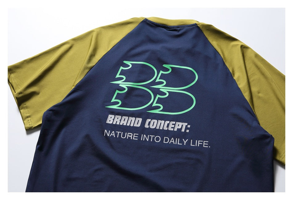 Back of a navy shirt with mustard raglan sleeves and a large green-and-white graphic and slogan.