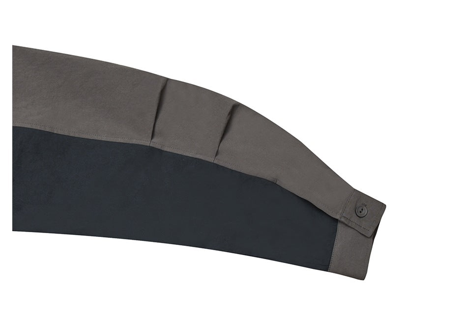 Close-up of a charcoal jacket sleeve with a dark contrast panel and buttoned cuff.