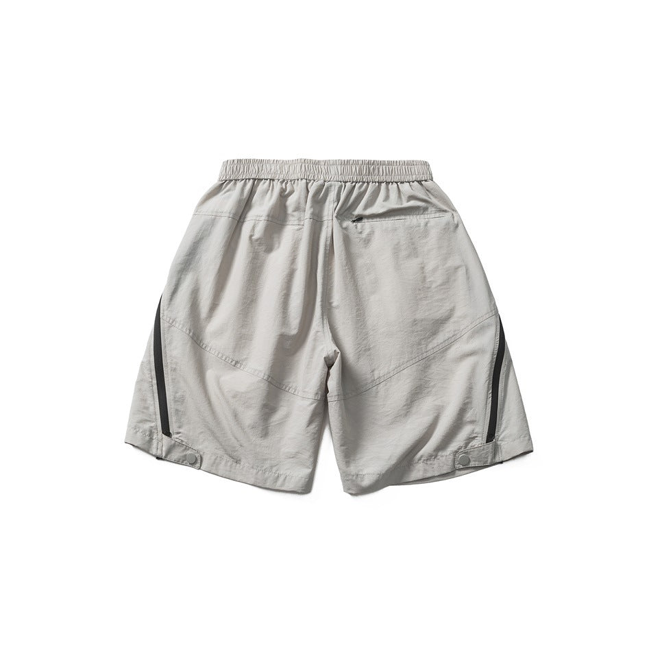 Back view of light gray shorts with elastic waistband, small zip pocket, black side trim and snap tabs at the hems