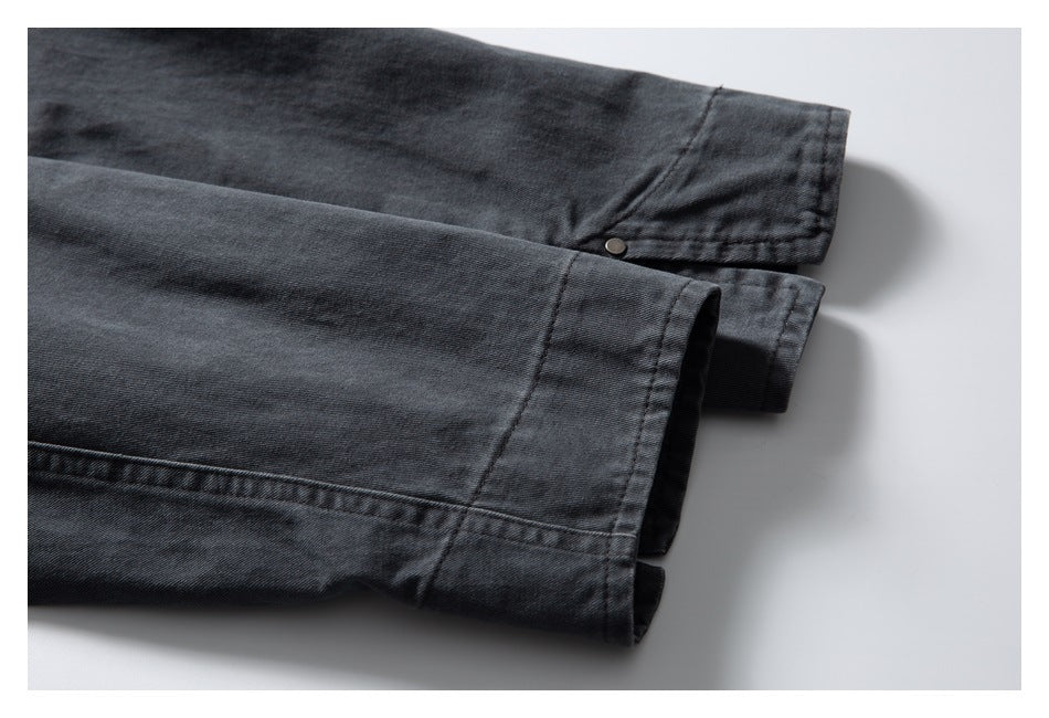Close-up of the dark charcoal garment's cuff and stitched sleeve hems.