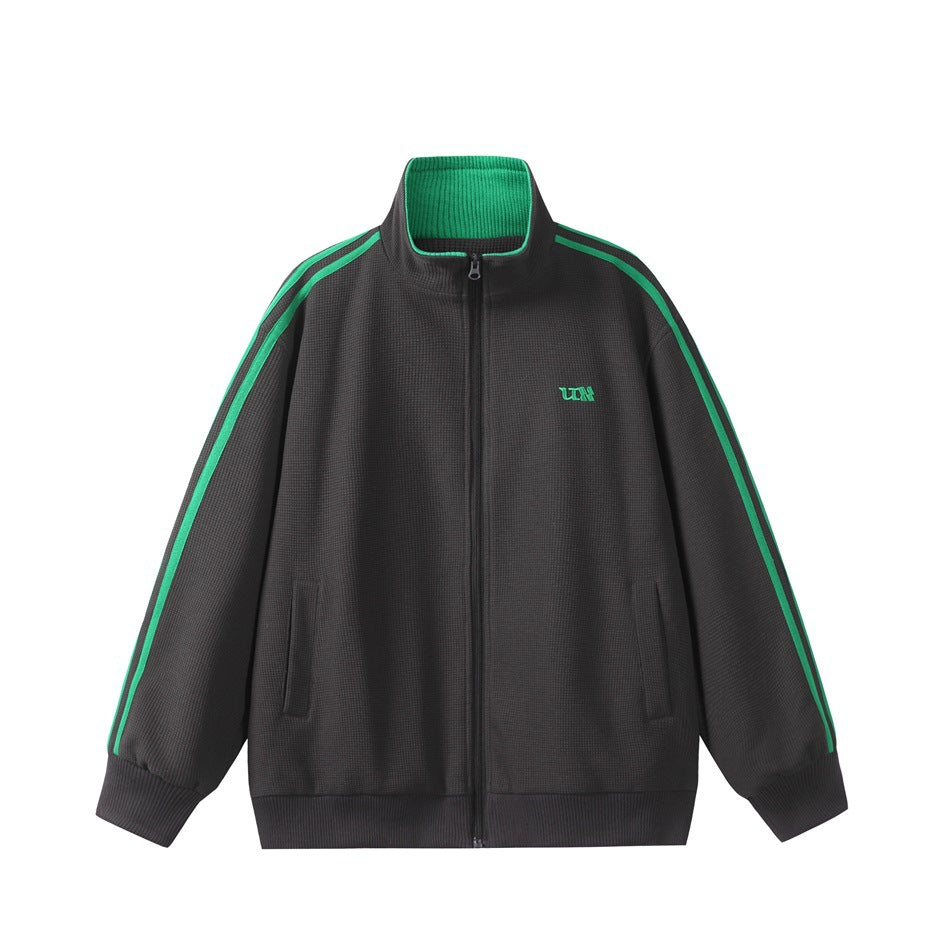 Dark gray zip-up track jacket with green sleeve stripes, green ribbed inner collar and a small green chest logo