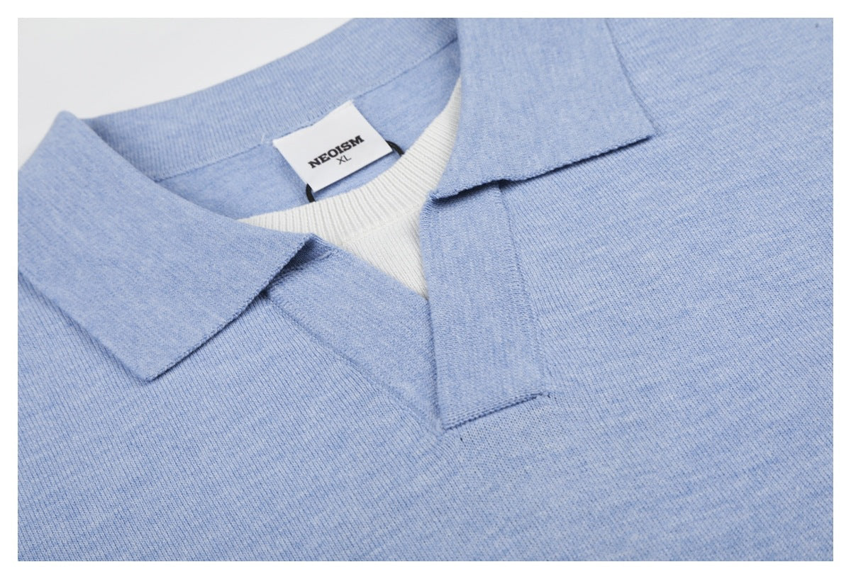 Close-up of the light blue polo's pointed collar, open placket, and NEOSISM XL label.