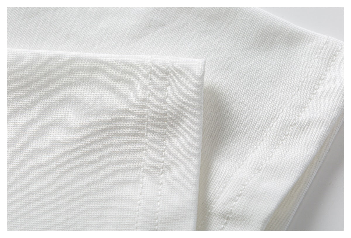 Close-up of white garment fabric showing folded edges and parallel stitching.