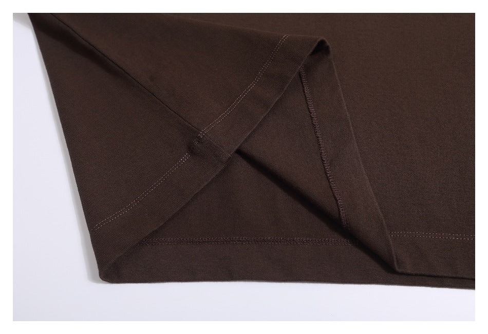 Close-up of the dark brown shirt's folded hem and stitching.