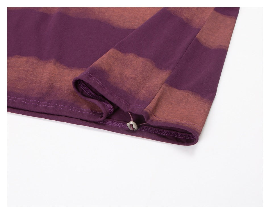 Close-up of the sweatshirt hem with a small metal toggle and plum-and-rust wavy stripes.