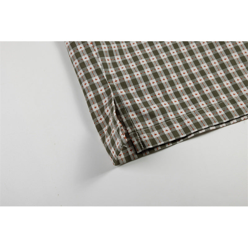 Close-up of the olive-gray checked shirt's short sleeve and stitched hem.