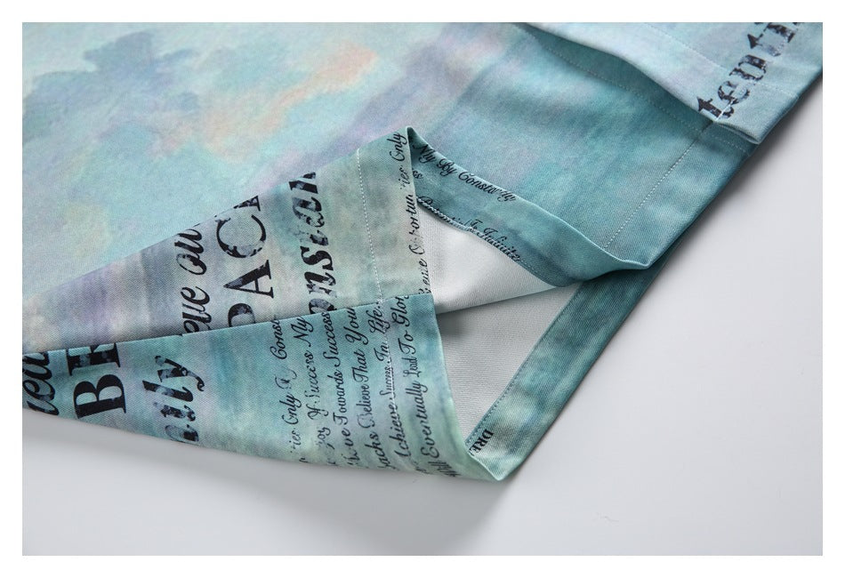 Close-up of a folded edge and seam on the aqua, black-lettered shirt.