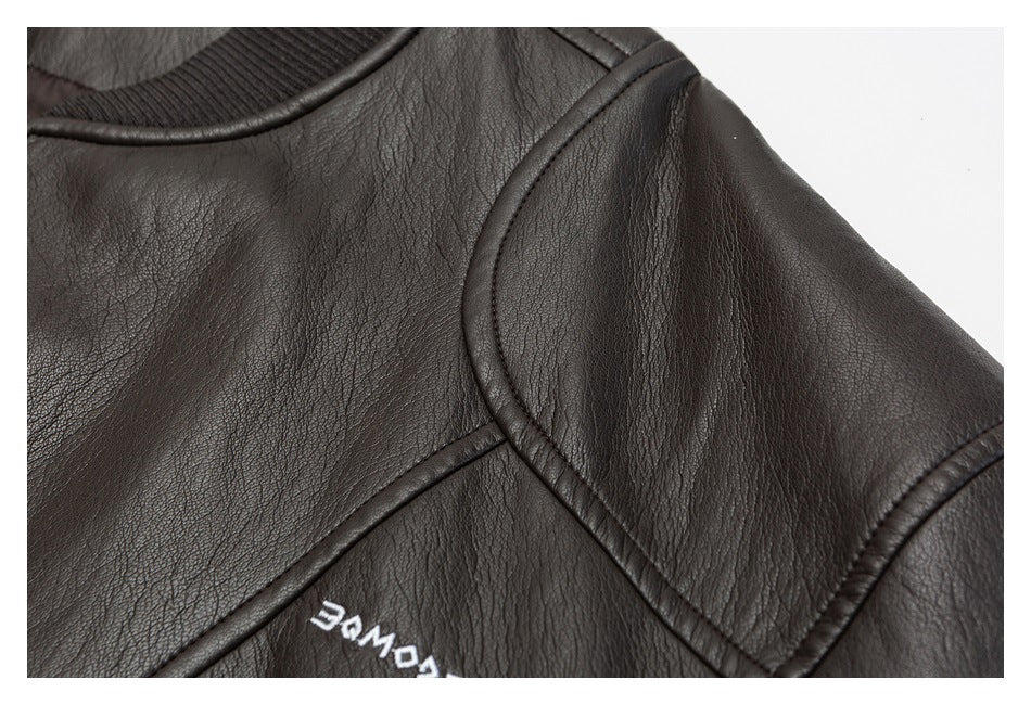 Close-up of the dark brown jacket's shoulder and sleeve piping, with a small white garment mark.