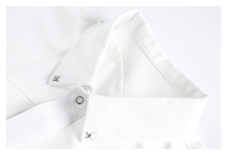 Close-up of a white shirt collar with silver star-shaped hardware and a metal eyelet.