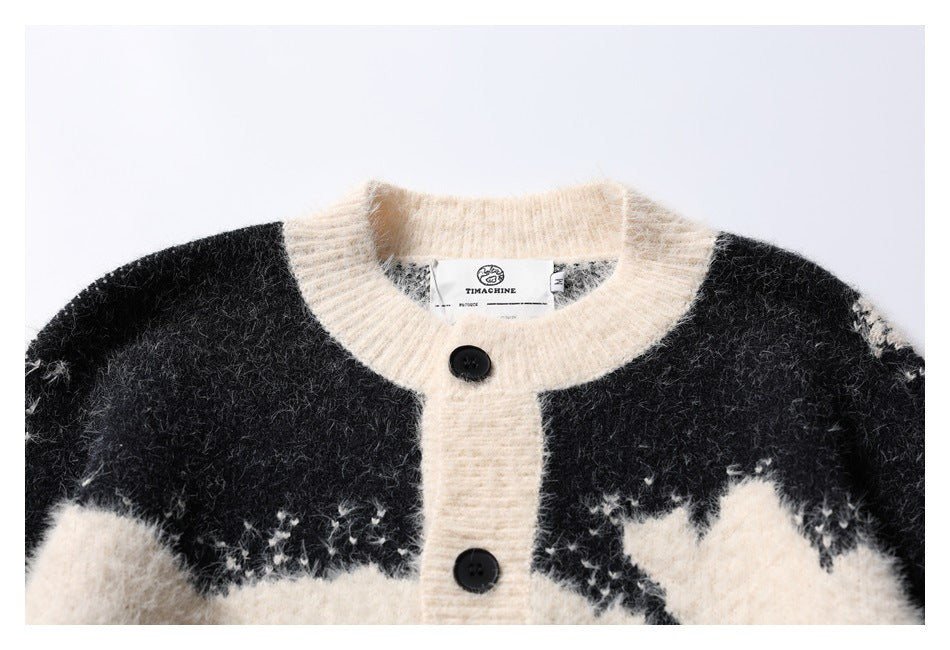 Close-up of the cardigan's ivory ribbed crew neckline, black buttons, and black-and-ivory pattern.