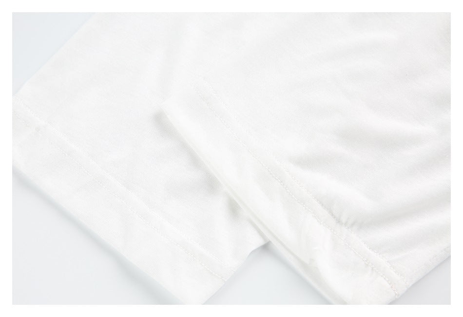 Close-up of white garment fabric with a stitched seam and folded hem.