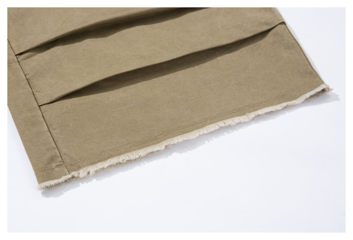 Close-up of the khaki trouser leg hem with a raw, frayed edge and visible stitching.