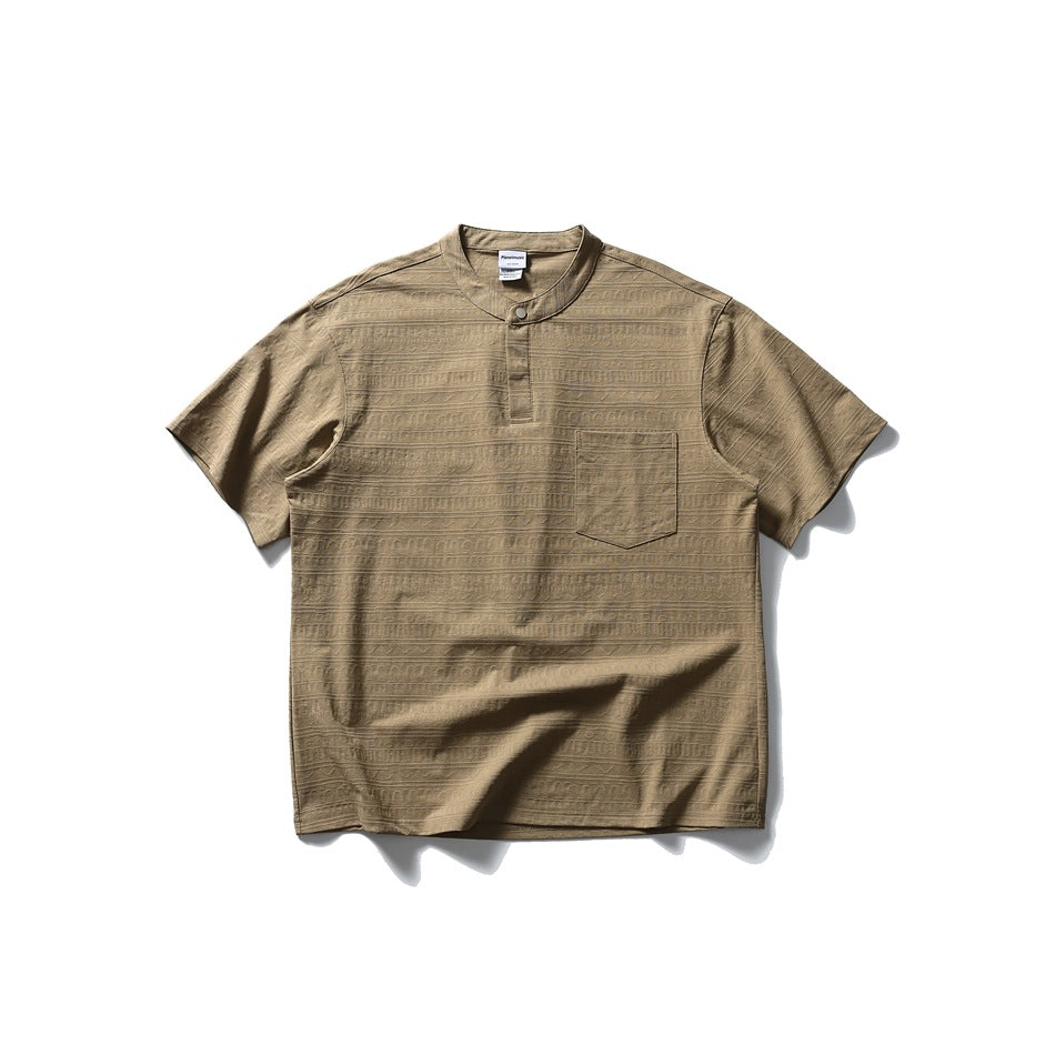 Camel short-sleeve Henley-style top with band collar, snap placket, chest pocket and textured pattern, flat lay