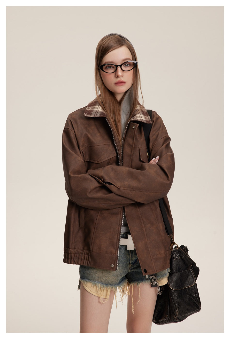 Model wearing an open brown jacket with plaid collar and flap pockets, paired with distressed denim shorts.