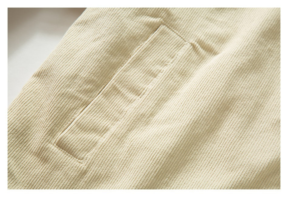 Close-up of a rectangular patch pocket on cream ribbed jacket fabric.