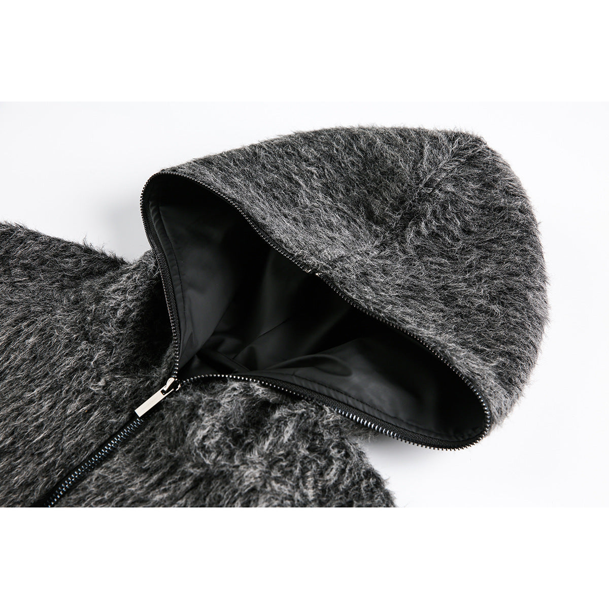 Close-up of a dark gray fuzzy hood opened to show its black lining and zipper.