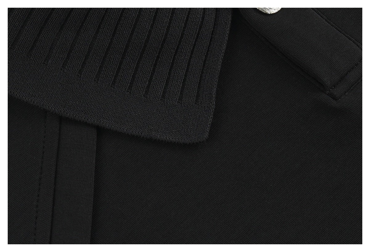 Close-up of the black shirt's ribbed collar and stitched front placket.