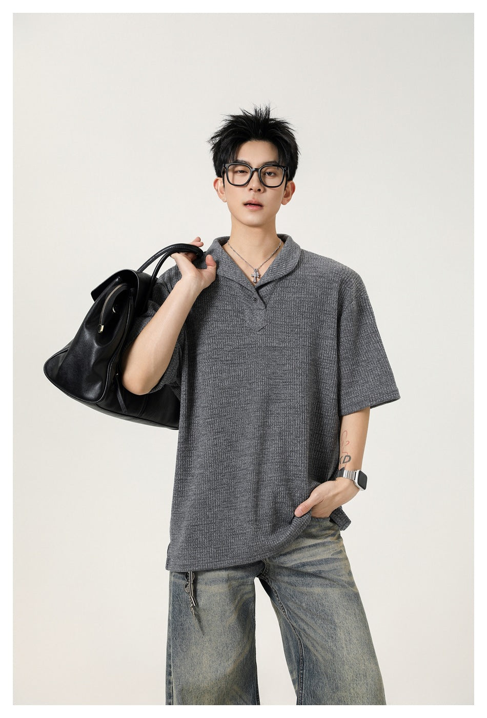 Model wearing a charcoal gray short-sleeve textured polo with a shawl collar and button placket.